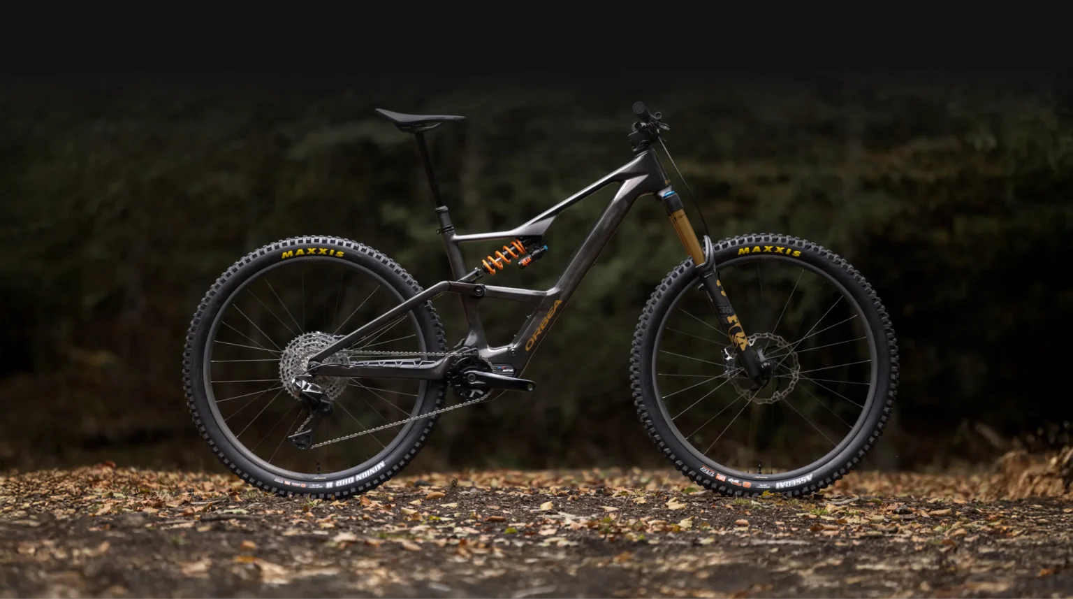 Orbea Rise LT negra completa con amortiguador de muelle en un bosque