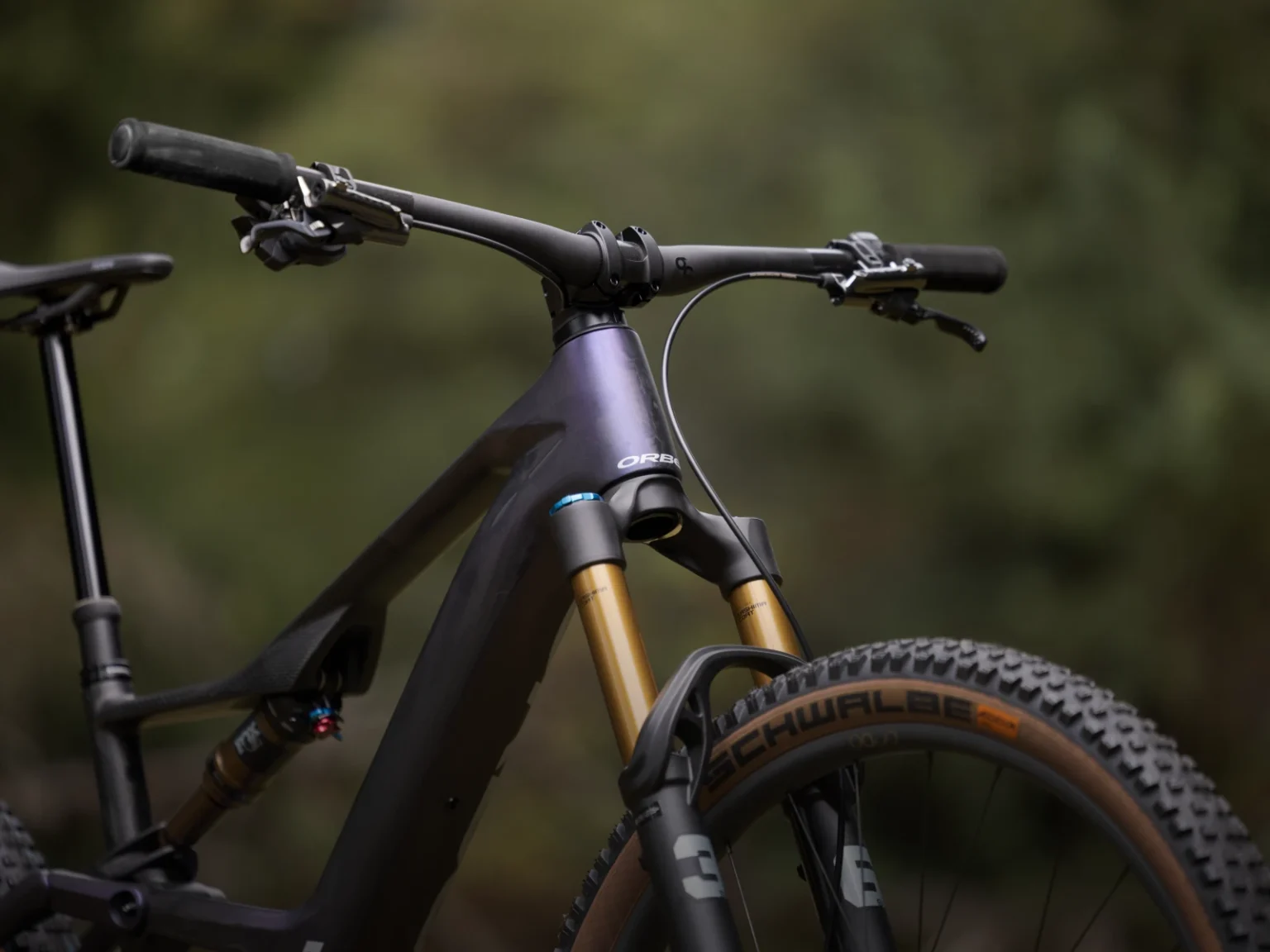 Parte delantera de una Orbea Rise morada con horquilla FOX y manillar